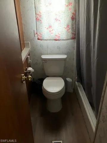 Bathroom featuring hardwood / wood-style floors and toilet