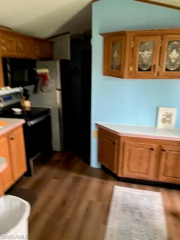 Kitchen featuring stove, washer / dryer, and hardwood / wood-style floors