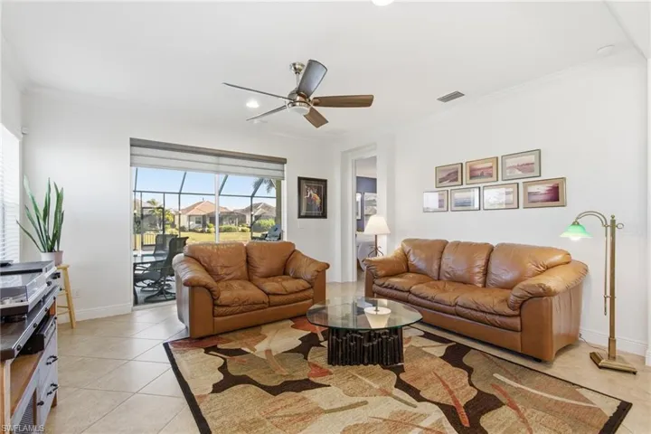 Living area with ornamental molding, light tile patterned flooring, ceiling fan, and recessed lighting