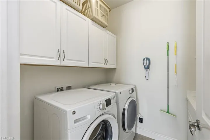 Laundry room with cabinet space and washer and clothes dryer
