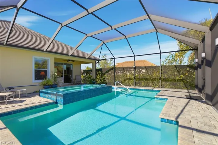 View of pool with a patio area, a sunroom, a lanai, and a pool with connected hot tub