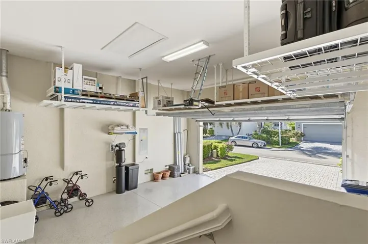 Garage with water heater, electric panel, and a garage door opener