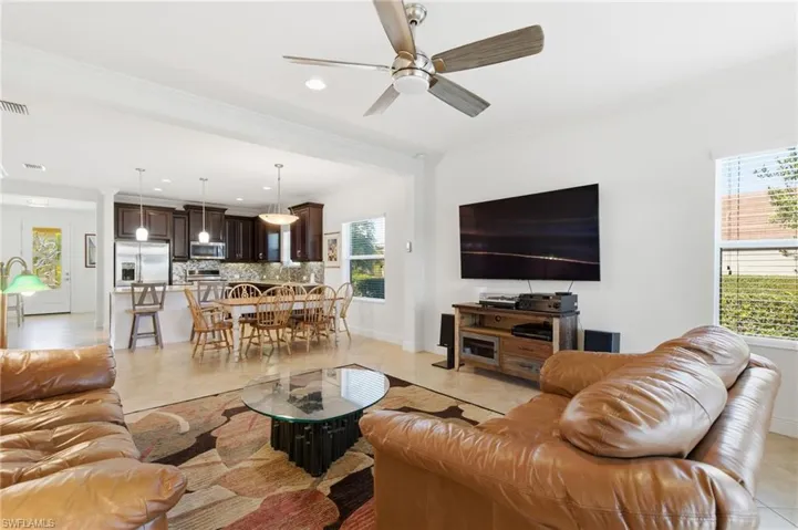 Living room featuring ornamental molding, light tile patterned floors, a ceiling fan, and recessed lighting