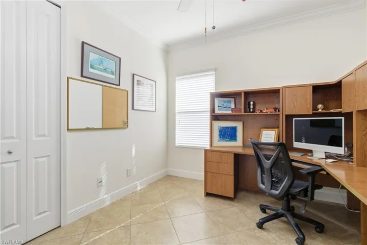 Office space with ornamental molding, ceiling fan, and light tile patterned floors