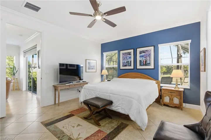 Bedroom with access to exterior, light tile patterned flooring, ornamental molding, and a ceiling fan