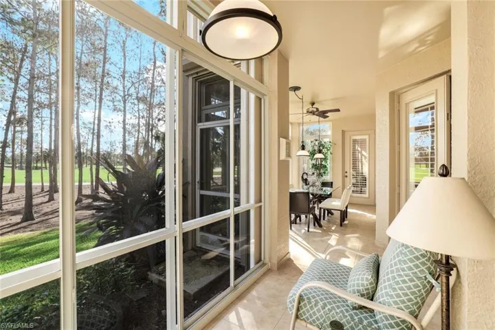 Sunroom with tile patterned flooring and a textured wall