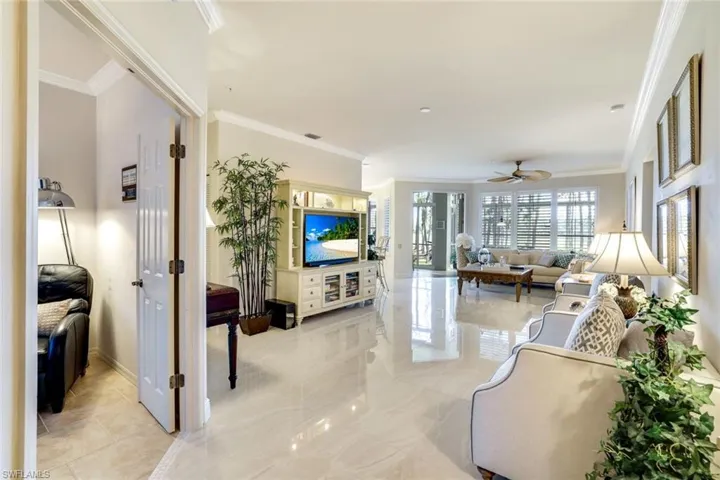 Living room with ornamental molding and a ceiling fan