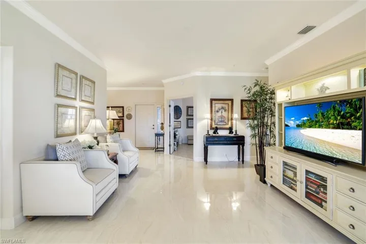 Living area featuring baseboards and crown molding