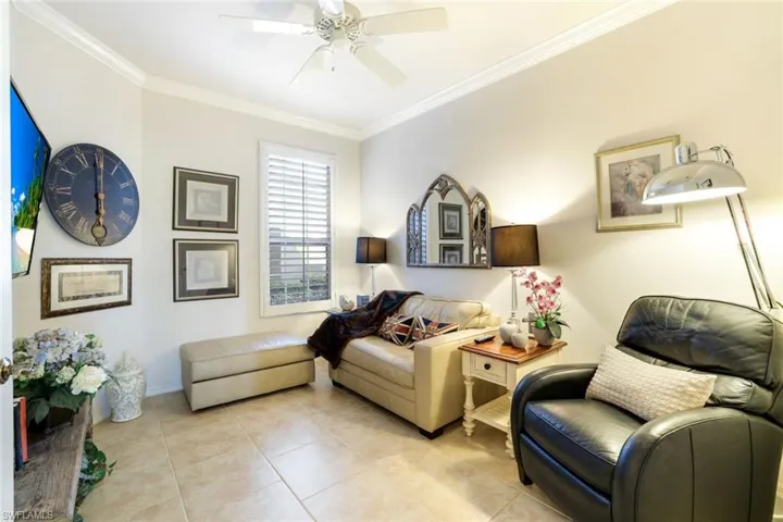 Living area featuring ornamental molding, ceiling fan, and tile patterned flooring