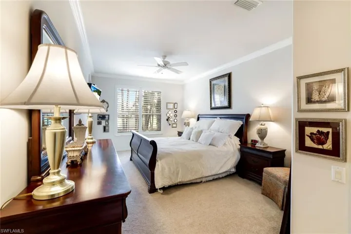 Bedroom featuring ornamental molding, carpet, and ceiling fan