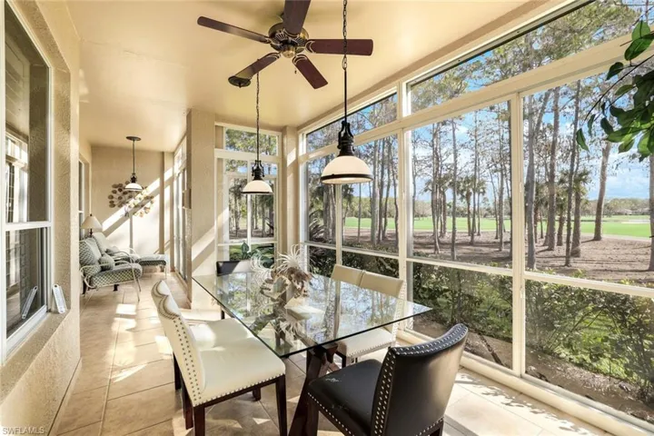 Sunroom featuring expansive windows, golf course view, and tile patterned flooring