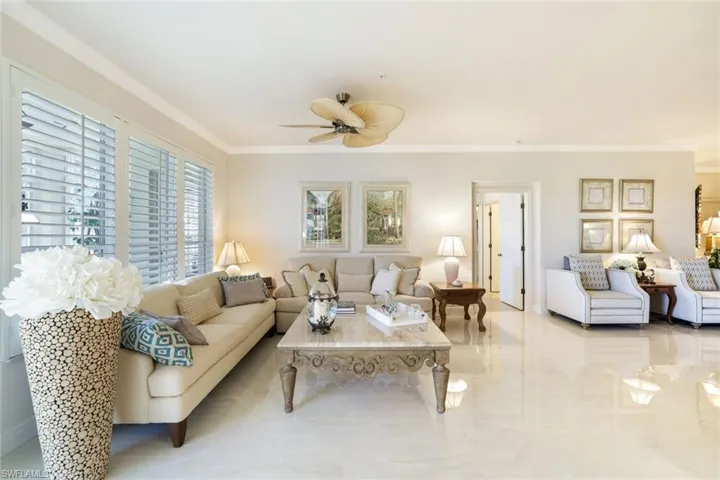 Living area featuring crown molding and a ceiling fan