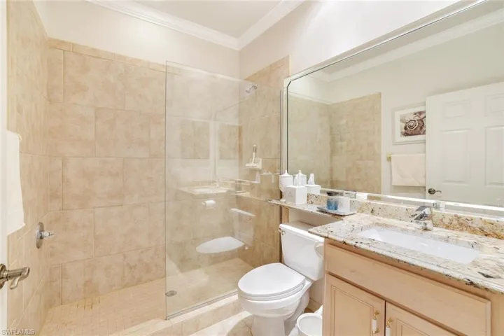 Bathroom with vanity, crown molding, and a walk in shower