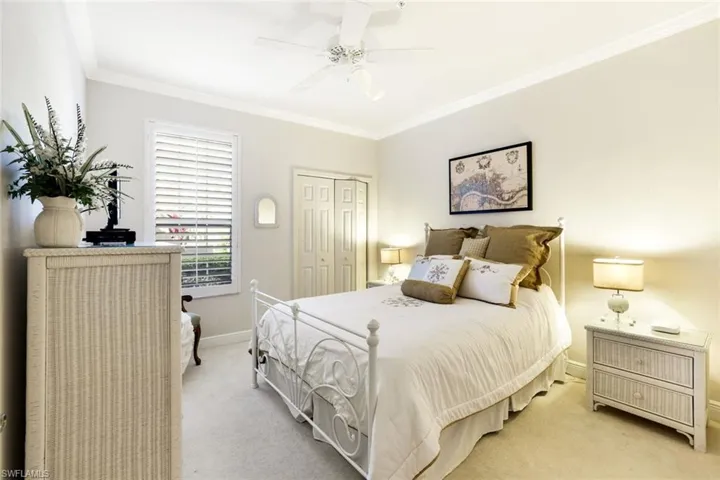 Bedroom featuring crown molding, a closet, light carpet, and a ceiling fan