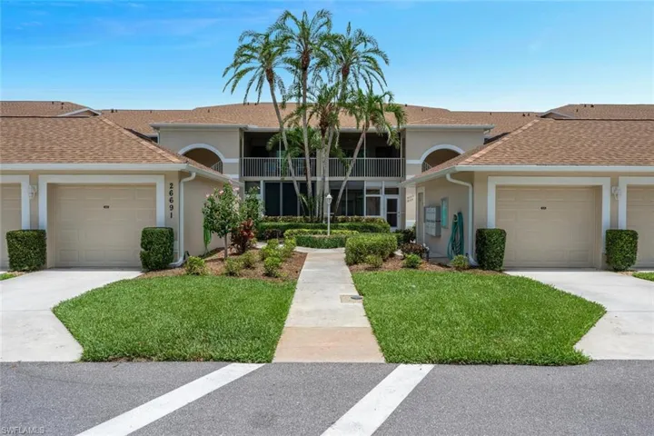 View of front of property with a garage, stucco siding, driveway, and a front lawn