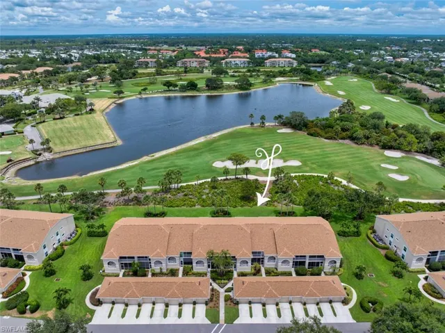 Aerial perspective of suburban area featuring a golf course and a nearby body of water