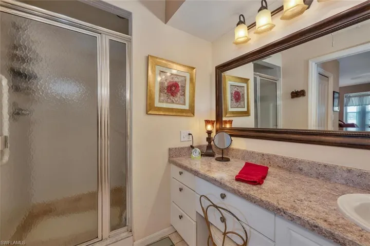 Full bath featuring a stall shower and vanity