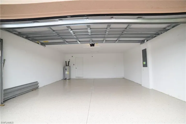 Garage featuring electric panel and water heater