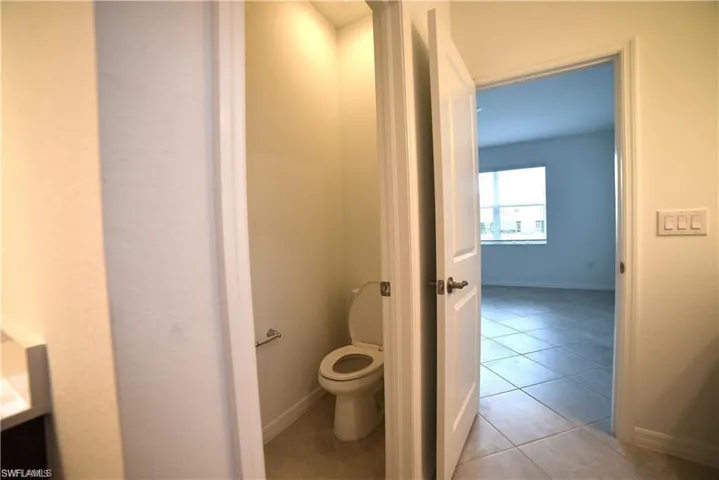 Bathroom featuring light tile patterned floors and toilet