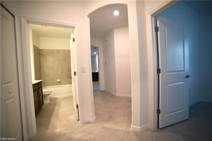Bathroom featuring vanity, shower / bathtub combination, and light tile patterned floors