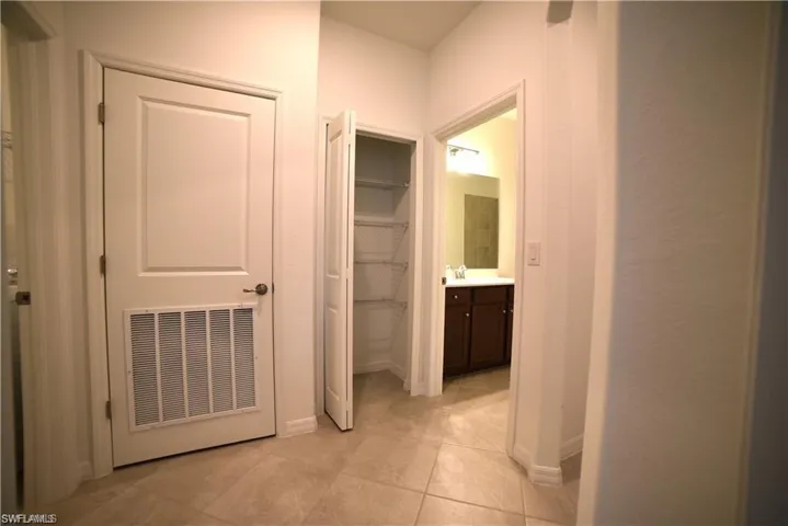 Hall with baseboards and light tile patterned floors
