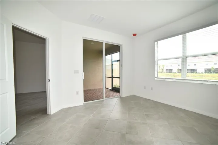 Unfurnished room with baseboards and light tile patterned flooring