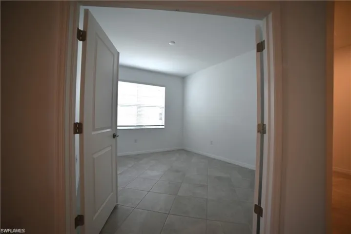 Corridor featuring baseboards and light tile patterned floors