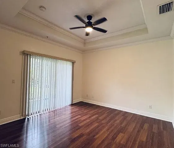 Master Bedroom Tray ceiling with crown molding, wood-finish flooring, ceiling fan, and sliding glass door