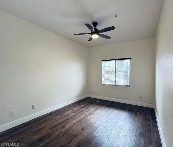 Wood-finish flooring, white walls, window with blinds, ceiling-mounted fan with light fixture
