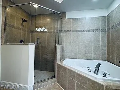 Master Bedroom Glass-enclosed shower with a rainfall showerhead, and a built-in jetted tub
