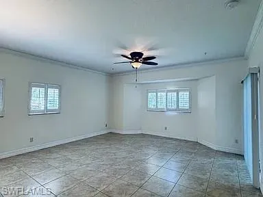 Recessed lighting, crown molding, ceiling fan with integrated light, tile flooring, and windows with plantation shutters