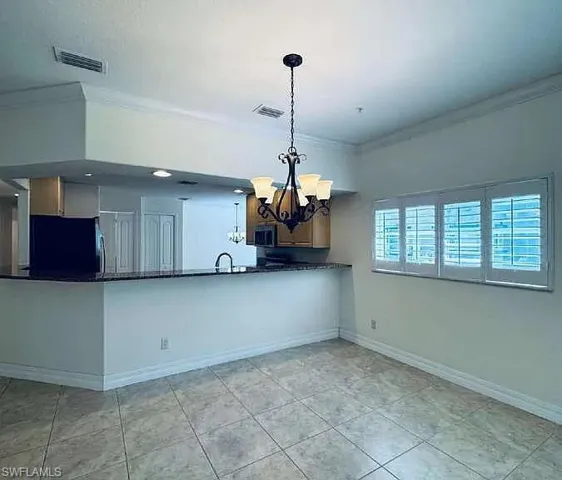 Open-concept kitchen with a breakfast bar, granite countertops, and wood cabinetry
