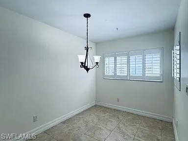 Tile flooring, plantation shutters, and a classic chandelier
