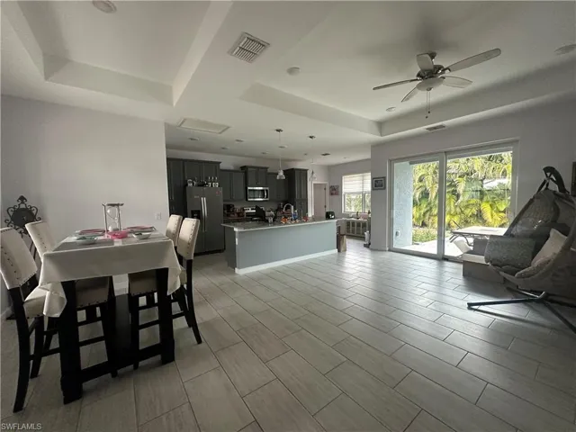 Dining space featuring ceiling fan and a tray ceiling