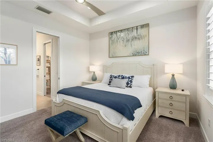 Bedroom with a tray ceiling and carpet