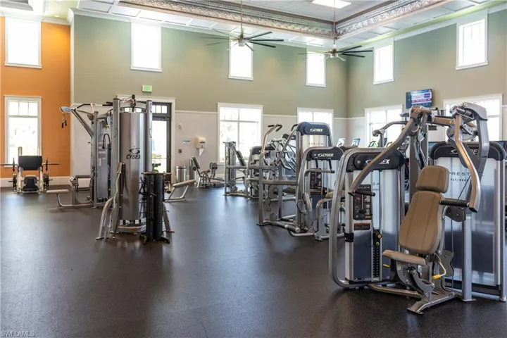 Exercise room with a towering ceiling and ceiling fan
