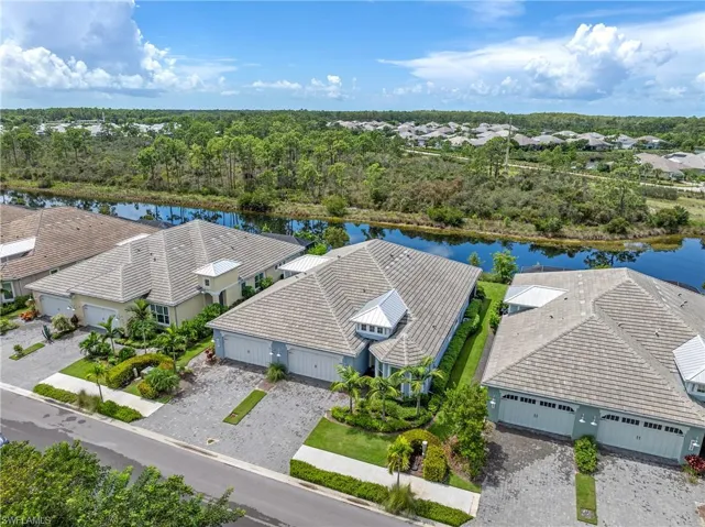 Aerial perspective of suburban area featuring a large body of water and a tree filled landscape