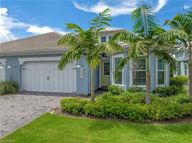 View of front of house with stucco siding, decorative driveway, a tiled roof, and an attached garage