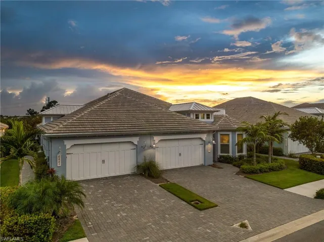 View of front of home featuring a garage, decorative driveway, a tiled roof, and stucco siding