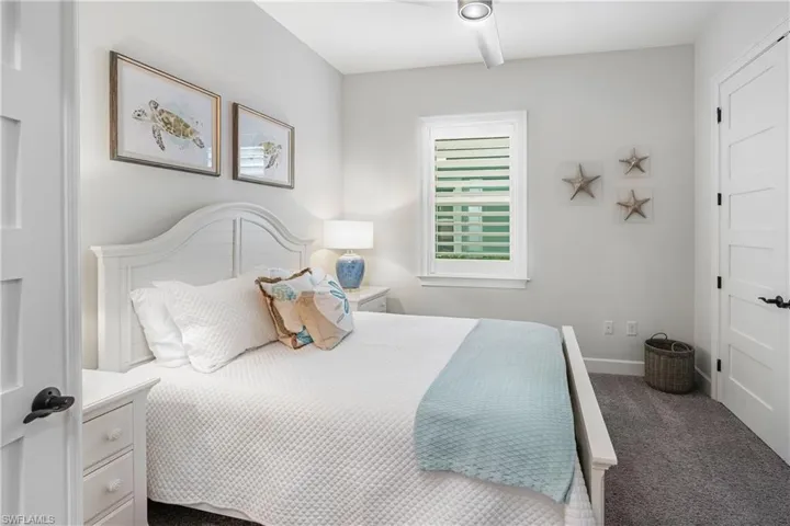 Bedroom featuring dark carpet and baseboards