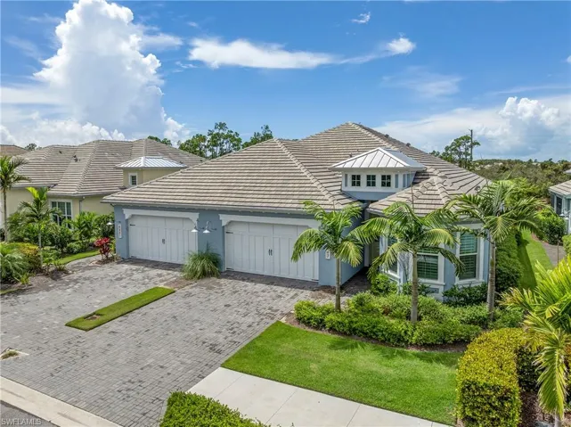 View of front facade featuring stucco siding, decorative driveway, and an attached garage
