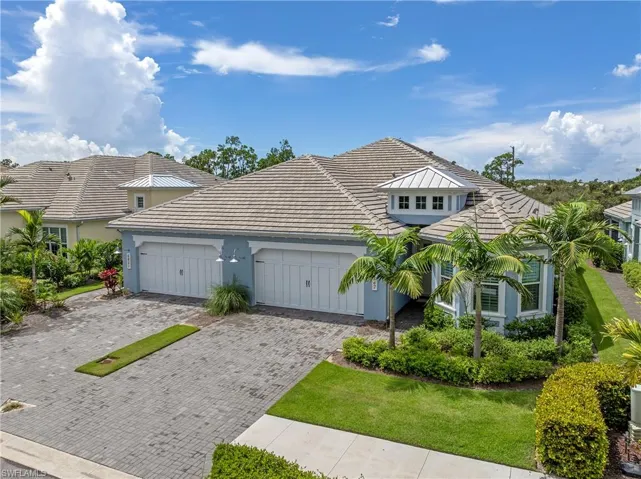 View of front facade with decorative driveway, stucco siding, a garage, and a tile roof
