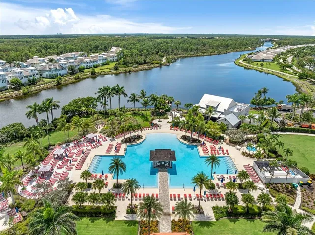 Aerial perspective of suburban area with a nearby body of water and a pool