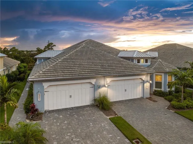 View of front of property featuring stucco siding, decorative driveway, and a garage