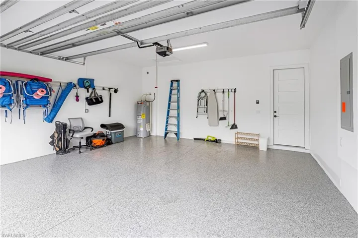 Garage featuring electric water heater and electric panel