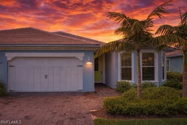 View of front of house featuring stucco siding, an attached garage, decorative driveway, and a tile roof