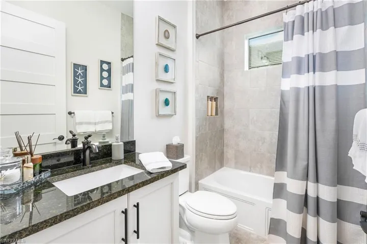 Bathroom with shower / tub combo and vanity