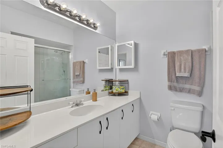 Full bathroom with vanity, a shower stall, and light tile patterned floors