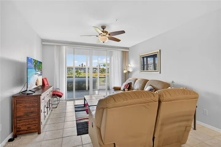 Living room with ceiling fan and light tile patterned floors
