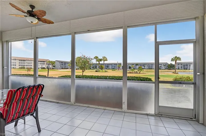 Sunroom featuring view of golf course and tile patterned floors